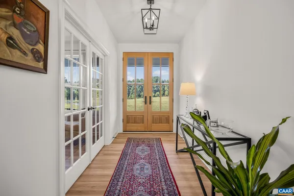 a view of a hallway with wooden floor and windows