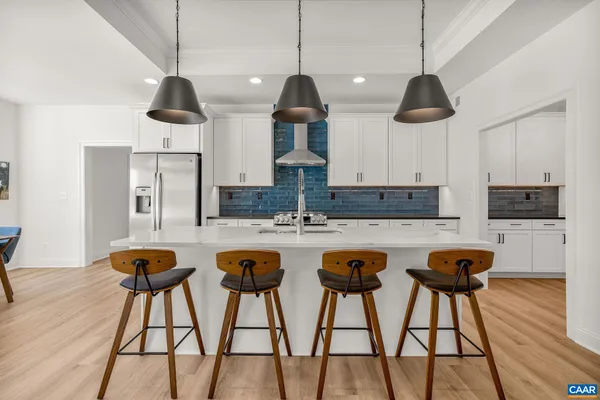 a kitchen with stainless steel appliances white cabinets and wooden floor