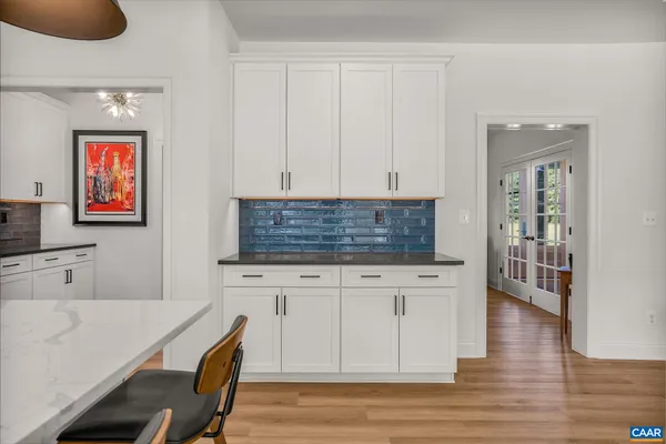 a kitchen with stainless steel appliances granite countertop a refrigerator a oven a white stove a sink a island with a dining table and chairs