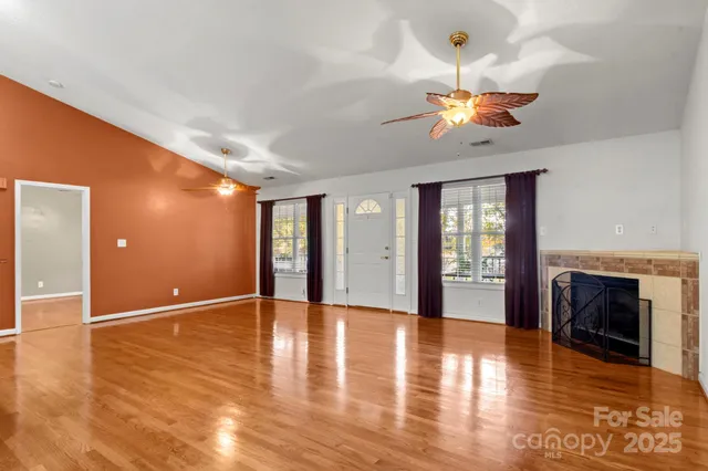 a view of a livingroom with wooden floor and a ceiling fan