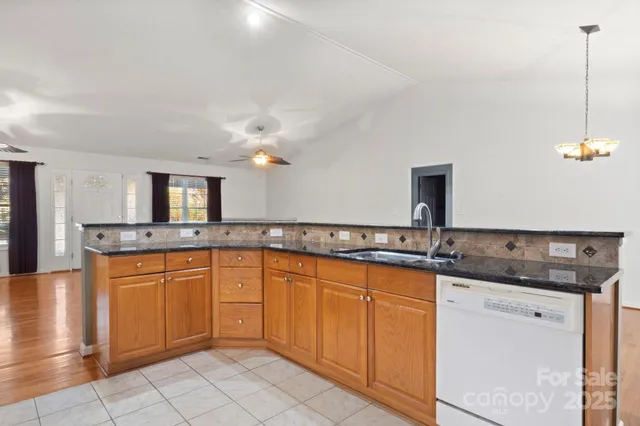 a large kitchen with granite countertop a sink and dishwasher stove top oven