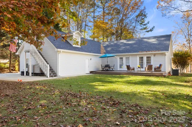 a view of a patio with couches and a table and chairs with wooden floor and fence