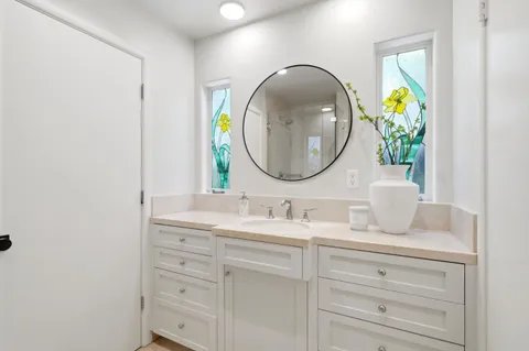 a bathroom with a granite countertop sink and a mirror