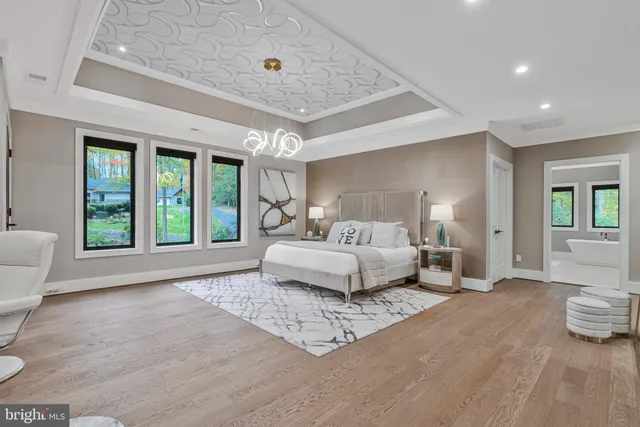 a living room with furniture a large window and wooden floor