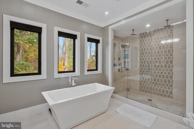 a kitchen with stainless steel appliances a sink a stove a refrigerator cabinets and chairs