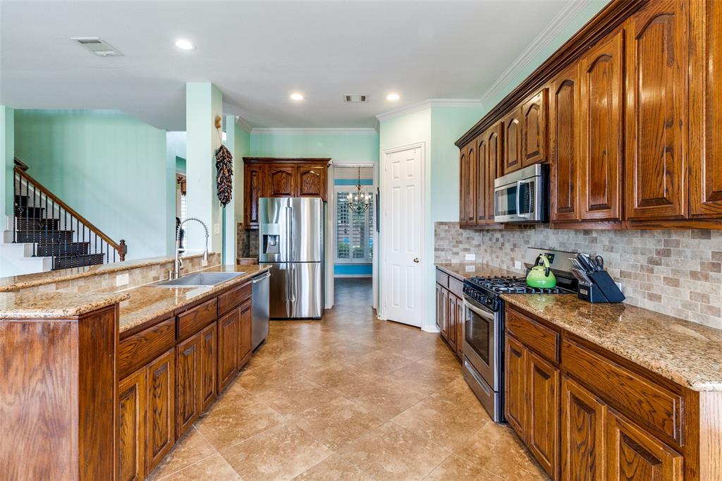 1802 Benedict Court Rowlett, TX 75088 - Photo 9 of 30 a kitchen with stainless steel appliances granite countertop wooden cabinets a stove top oven a sink and dishwasher