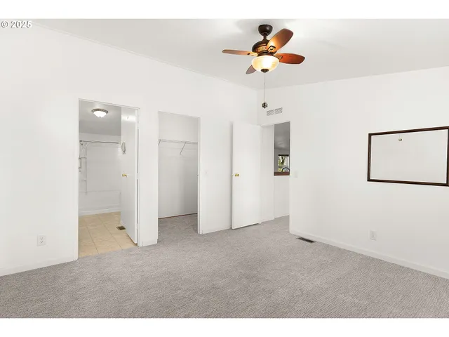 a view of empty room with ceiling fan
