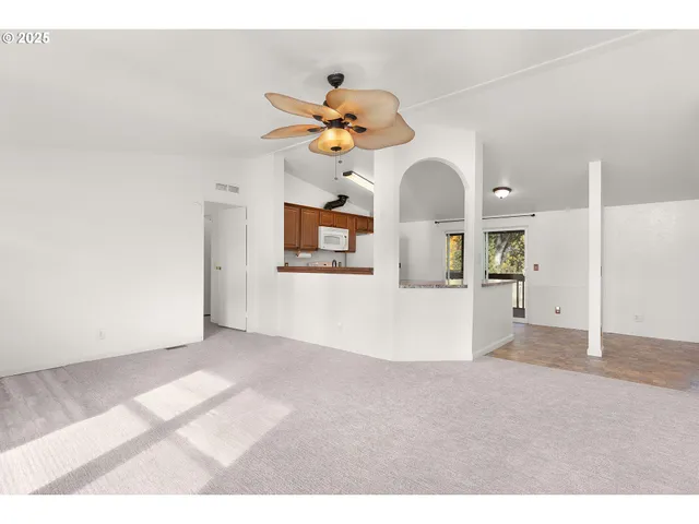 a view of a room with a chandelier fan and windows