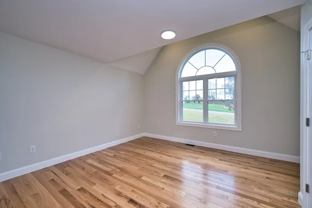 an empty room with wooden floor and a window