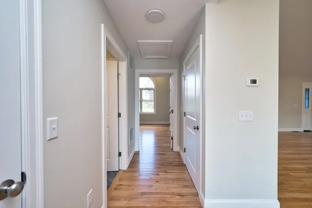 a view of a hallway with wooden floor and closet