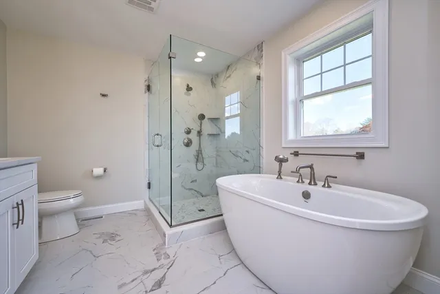 a white bath tub sitting next to a toilet