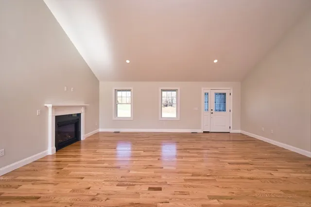 a view of an empty room with a window and fireplace