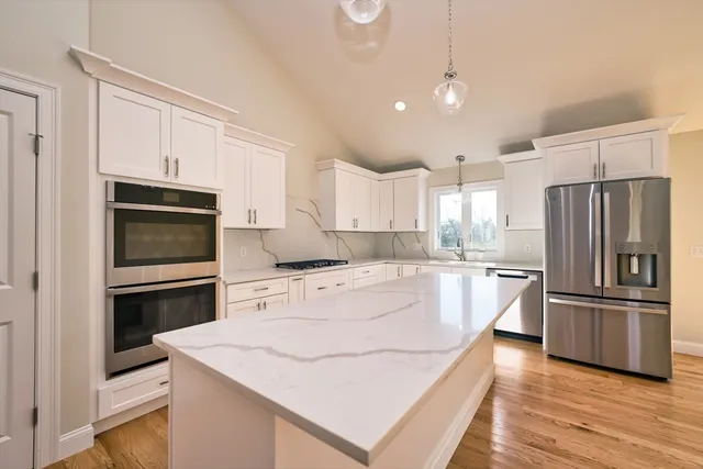 a kitchen with a refrigerator stove and wooden cabinets