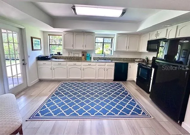 a kitchen with stainless steel appliances granite countertop a stove top oven a sink dishwasher and a refrigerator