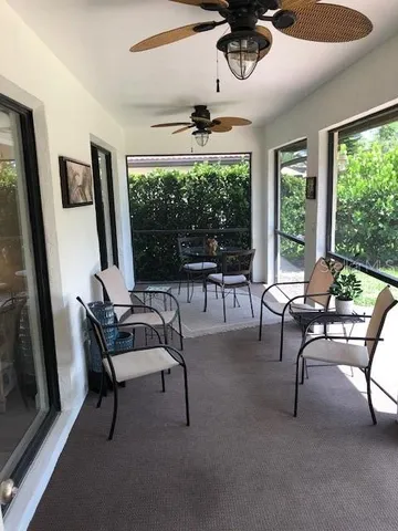 a living room with furniture a floor to ceiling window and a flat screen tv
