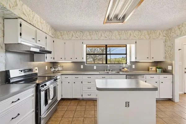 a kitchen with stainless steel appliances granite countertop a sink and cabinets