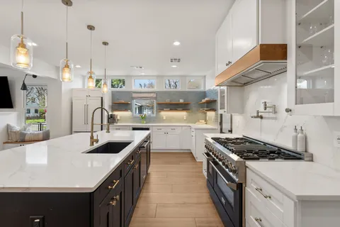 a kitchen with a sink stove top oven and cabinets