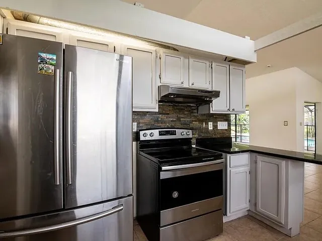 a kitchen with a refrigerator stove and cabinets