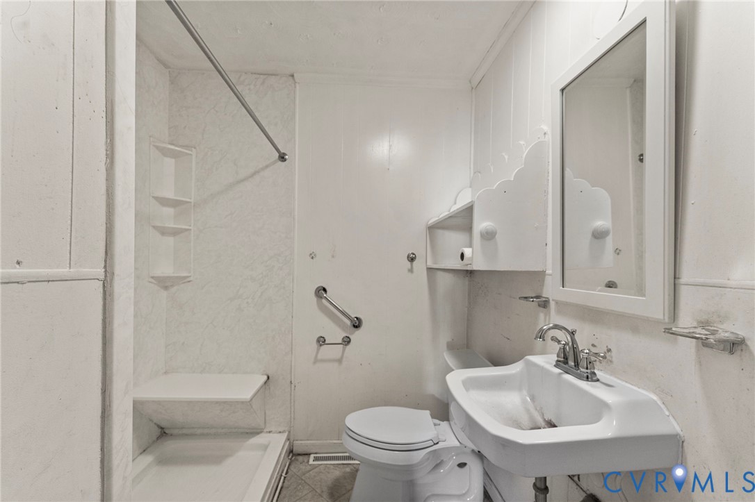 2925 West Strathmore Road Richmond, VA 23237 - Photo 11 of 25 a bathroom with a sink a toilet and shower