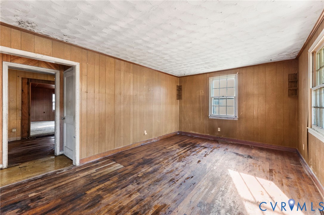 2925 West Strathmore Road Richmond, VA 23237 - Photo 3 of 25 a view of an empty room with wooden floor and a window