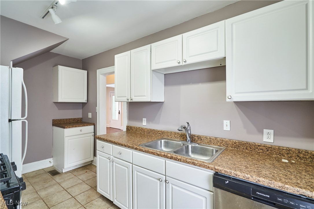 2152 Middlefield Road Cleveland, OH 44106 - Photo 11 of 50 Kitchen with sink, white refrigerator, stainless steel dishwasher, black range with gas stovetop, and white cabinets