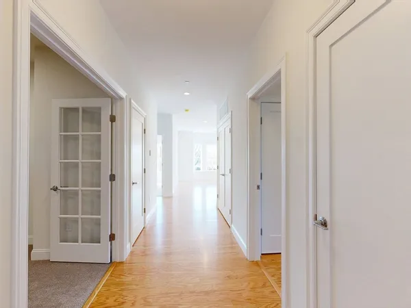 a view of a hallway with wooden floor and closet