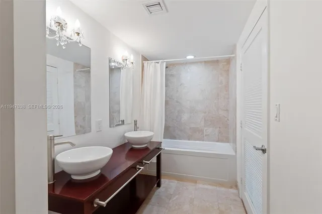 a bathroom with a granite countertop shower a mirror and a sink