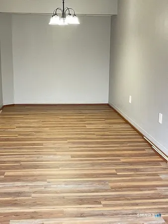 a view of an empty room with window and stairs