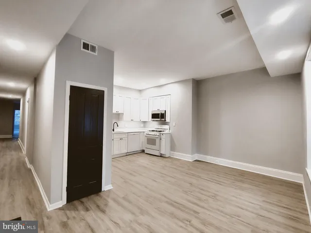 a kitchen with a refrigerator and white cabinets