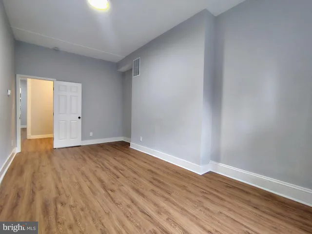 a view of an empty room with wooden floor