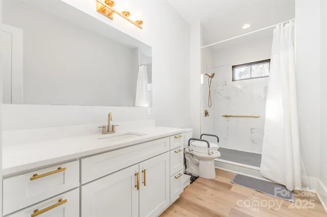 a bathroom with a sink a toilet and shower