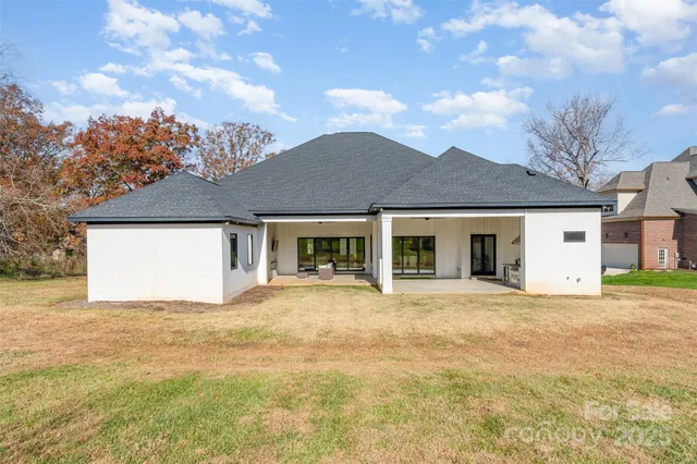 a front view of house with yard and trees in the background