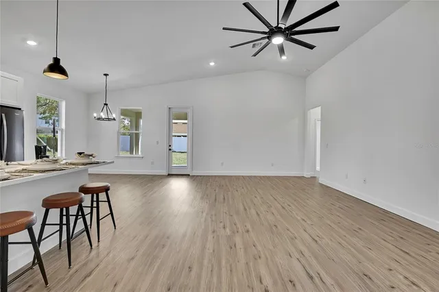 a kitchen with stainless steel appliances kitchen island granite countertop a sink and a refrigerator