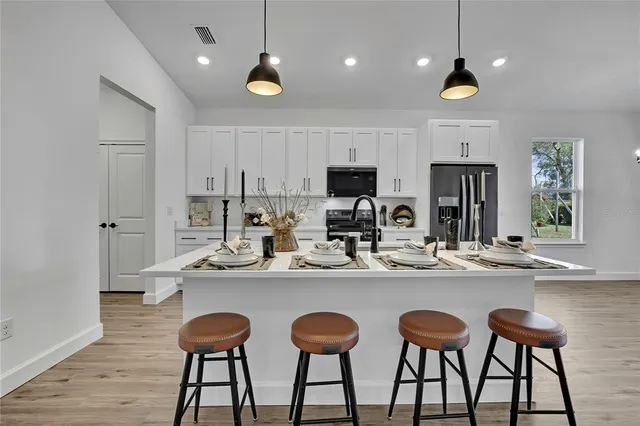 a kitchen with refrigerator cabinets dining table and chairs