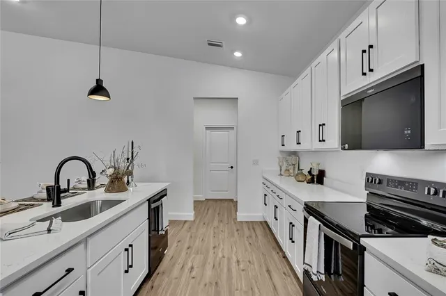a kitchen with stainless steel appliances a stove a microwave and cabinets