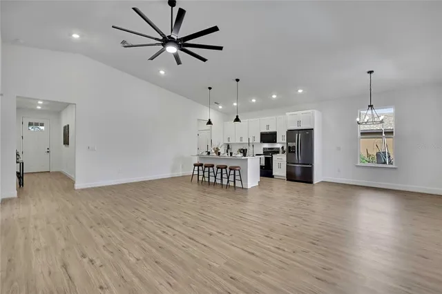 a view of a room with wooden floor and a ceiling fan