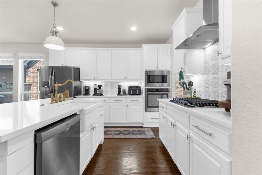 853 Field Crossing Little Elm, TX 76227 - Photo 7 of 24 a kitchen with stainless steel appliances a stove sink and cabinets
