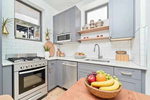 a kitchen with stainless steel appliances granite countertop a stove and a sink