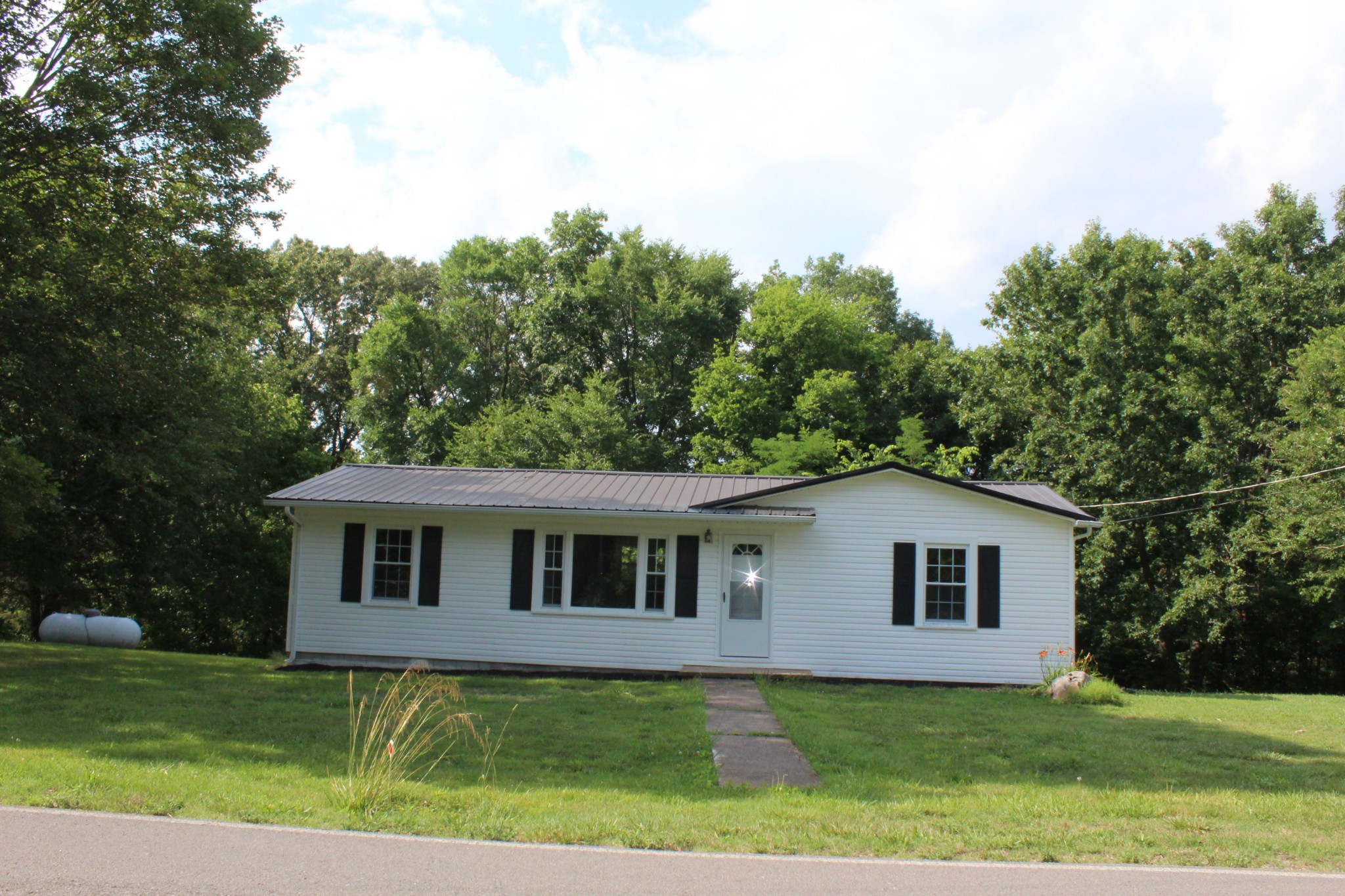1275 Herman Adams Road Cumberland City, TN 37050 - Photo 15 of 25 a view of a yard in front of a house with a large tree