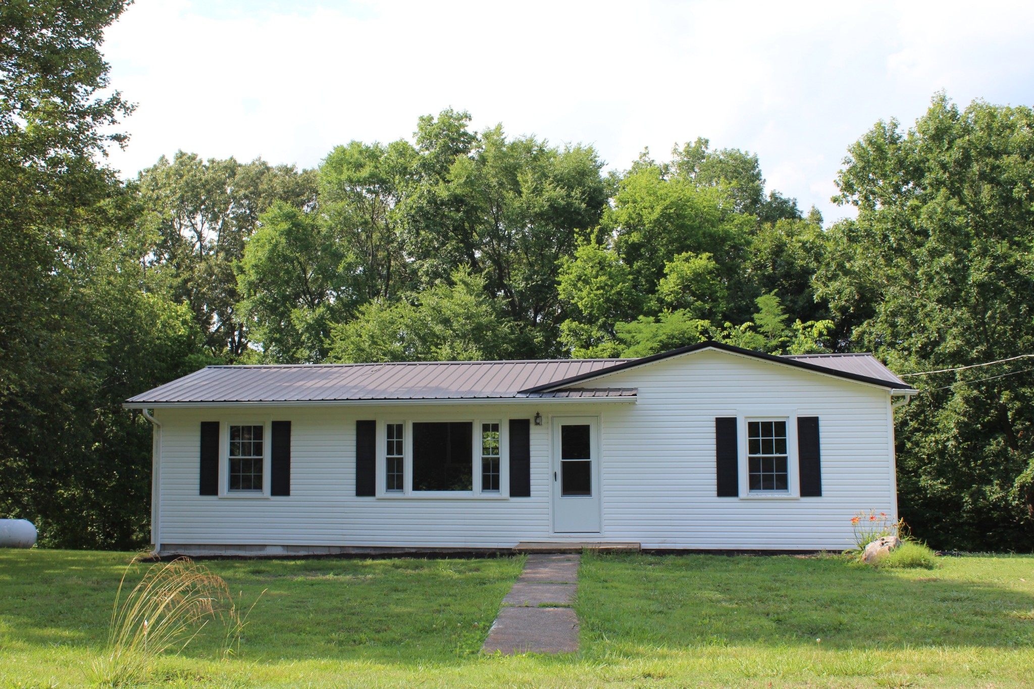 1275 Herman Adams Road Cumberland City, TN 37050 - Photo 2 of 25 a front view of a house with garden