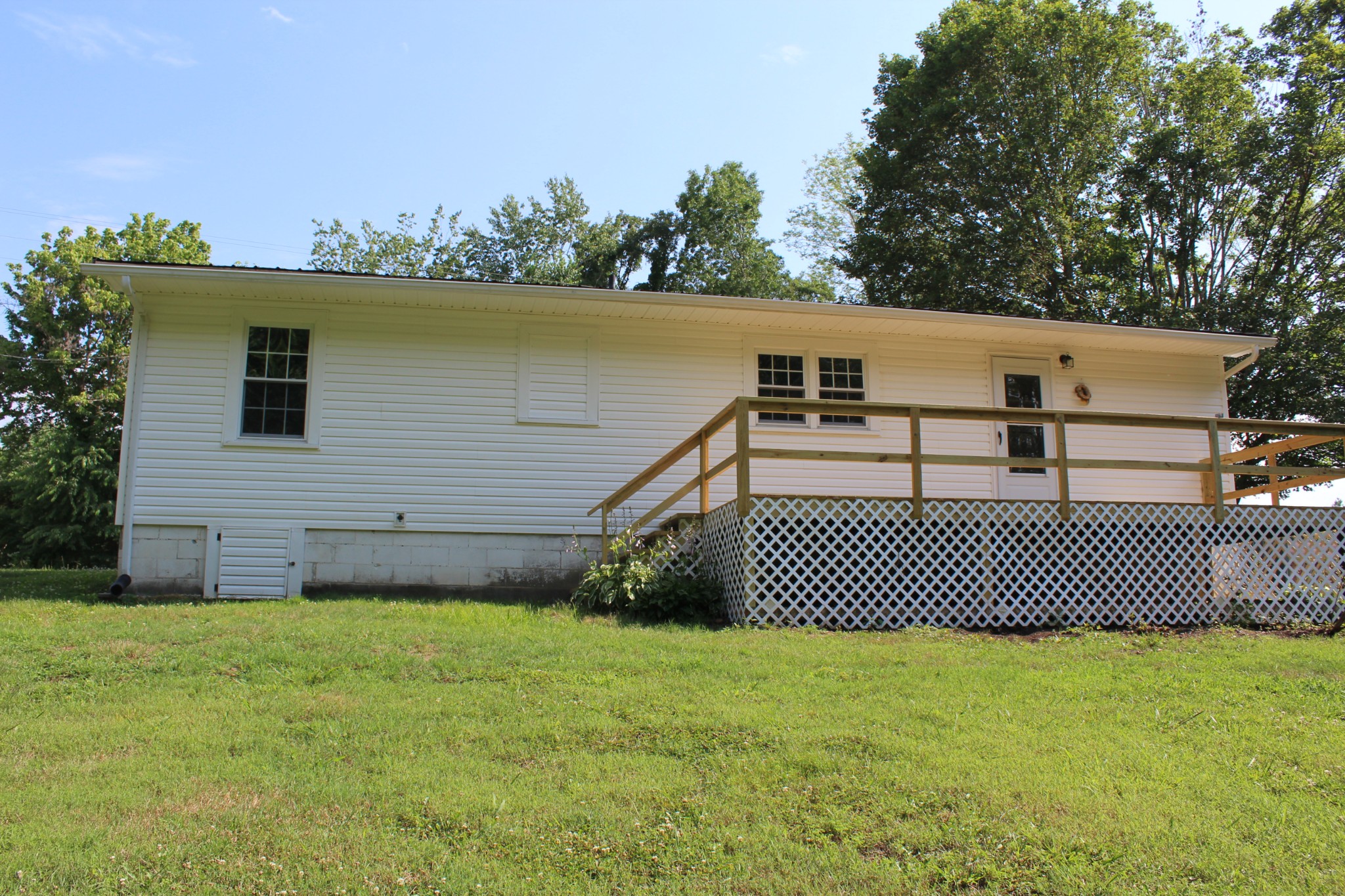 1275 Herman Adams Road Cumberland City, TN 37050 - Photo 3 of 25 a view of a white house with a big yard and large trees