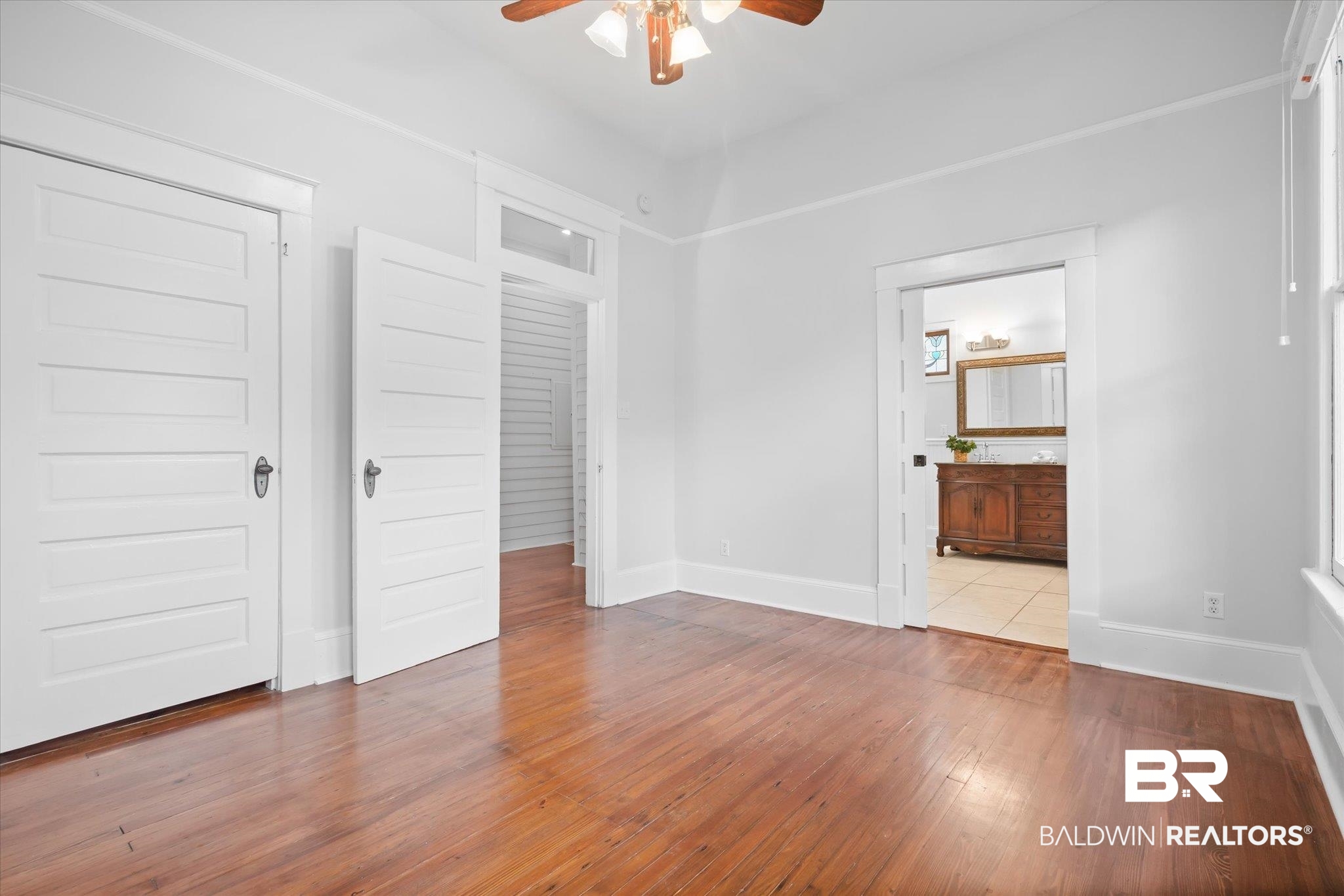 14 South Monterey Street Mobile, AL 36604 - Photo 12 of 41 Unfurnished bedroom featuring light hardwood / wood-style flooring, ceiling fan, ensuite bath, and a closet