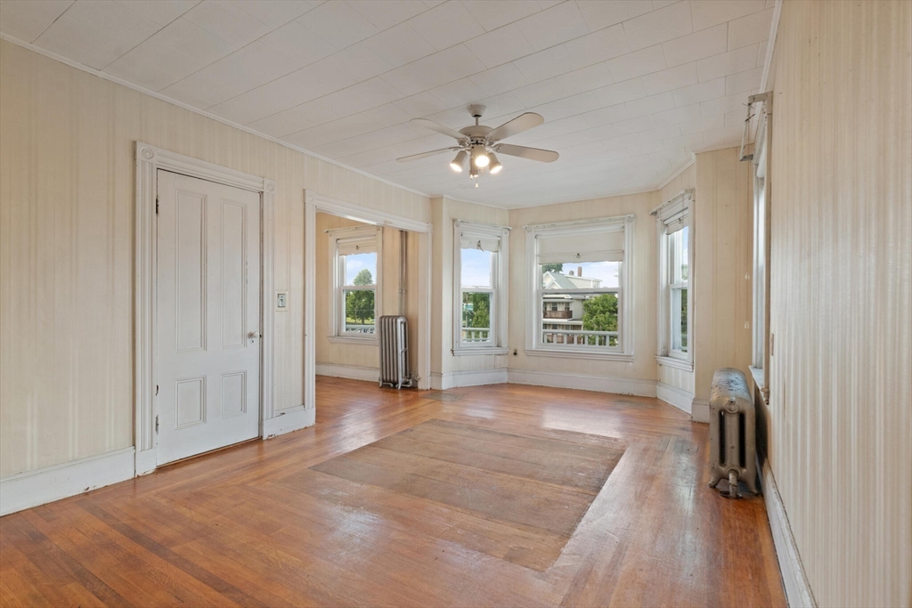 200 Broadway Somerville, MA 02145 - Photo 4 of 25 a view of a big room with windows and chandelier fan
