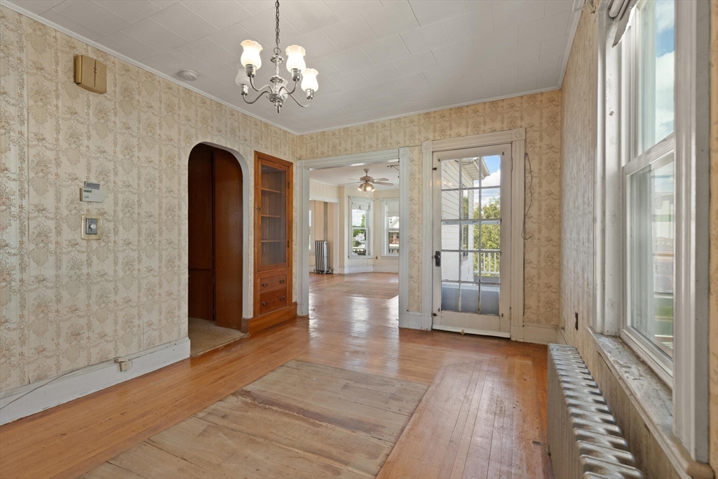 200 Broadway Somerville, MA 02145 - Photo 6 of 25 a view of a hallway with wooden floor and a chandelier