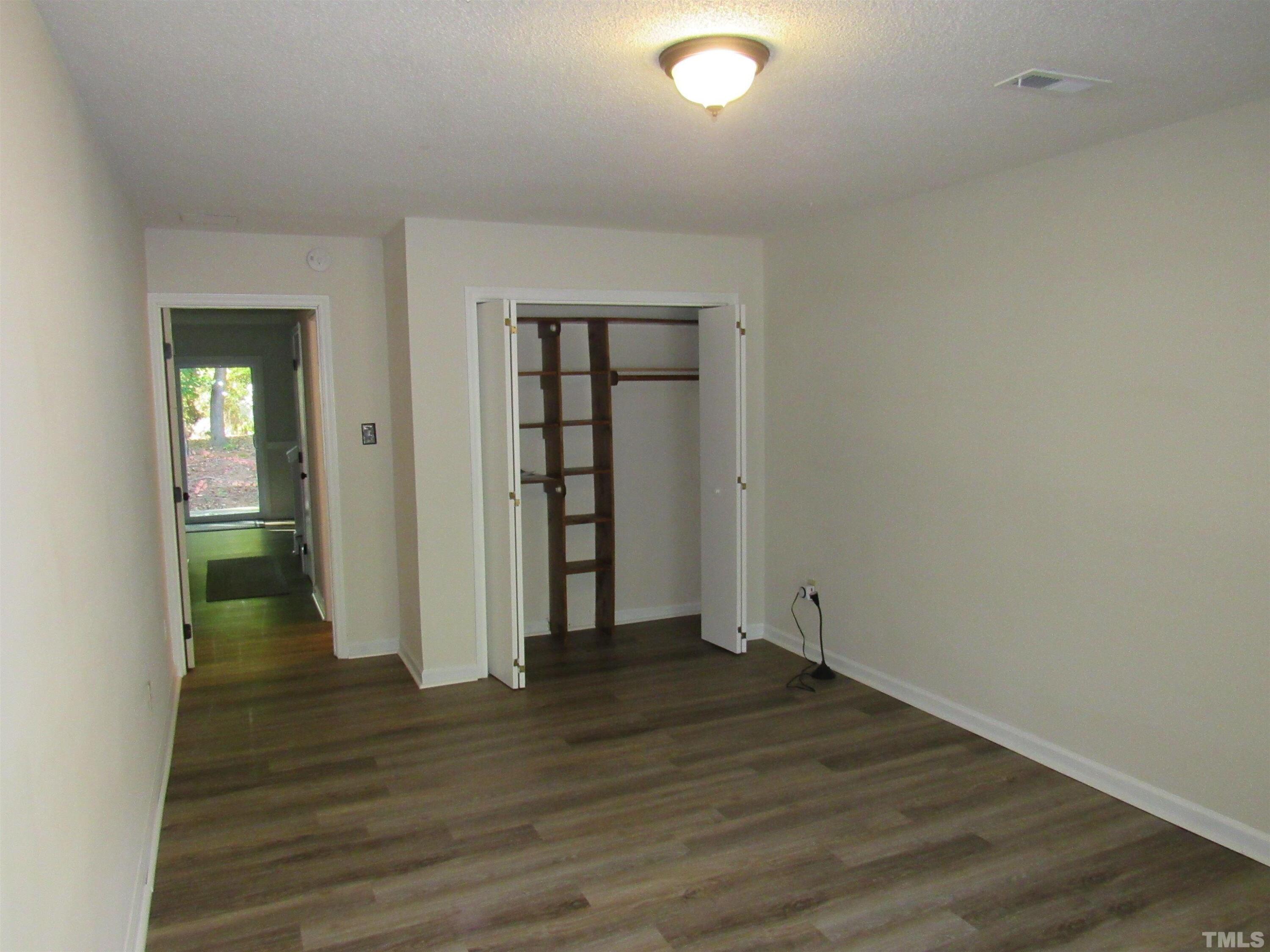 4309 Hunters Club Drive, Unit 4309 Raleigh, NC 27606 - Photo 11 of 35 an empty room with wooden floor and closet