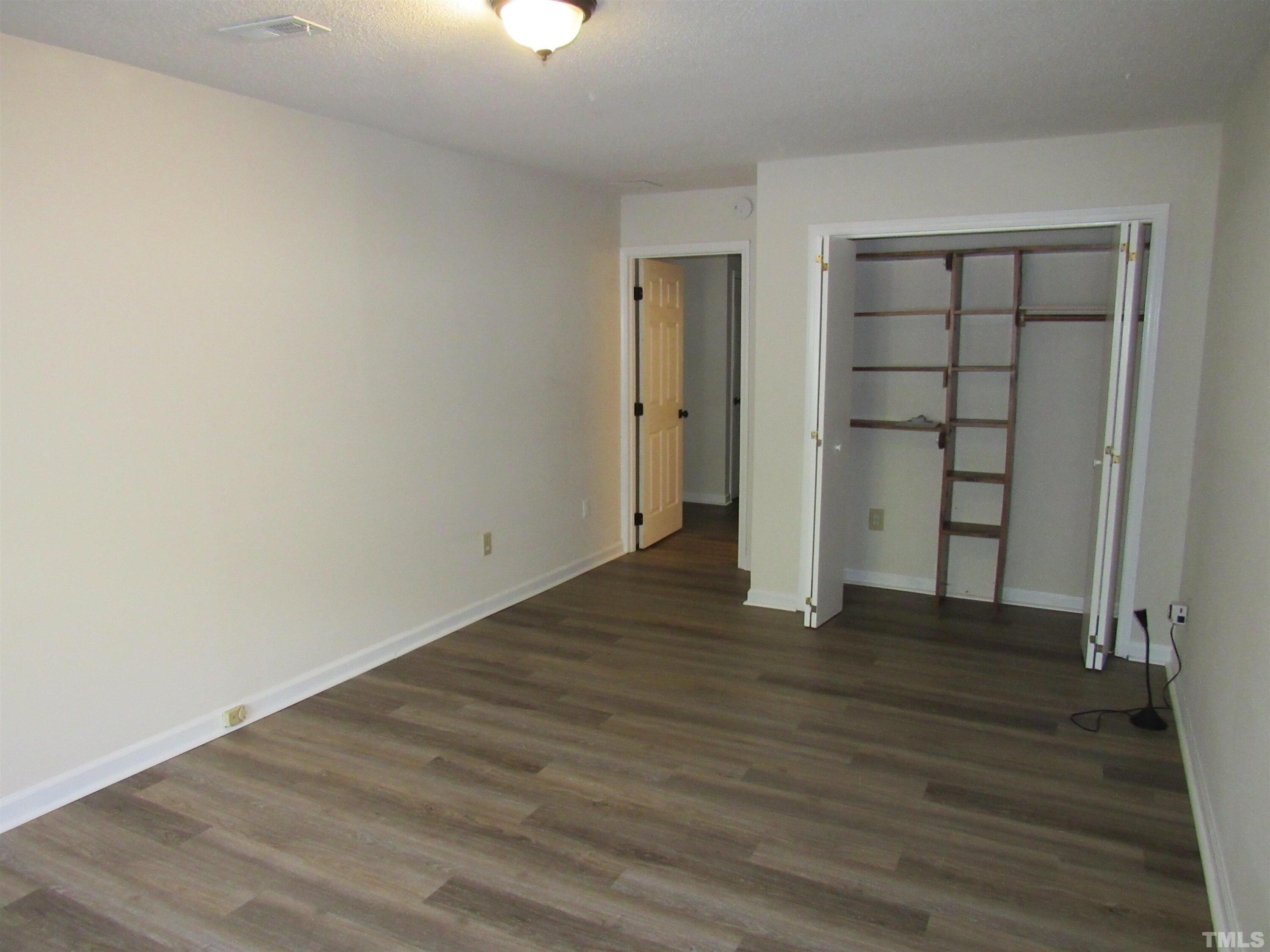 4309 Hunters Club Drive, Unit 4309 Raleigh, NC 27606 - Photo 12 of 35 a view of an empty room with wooden floor and a window