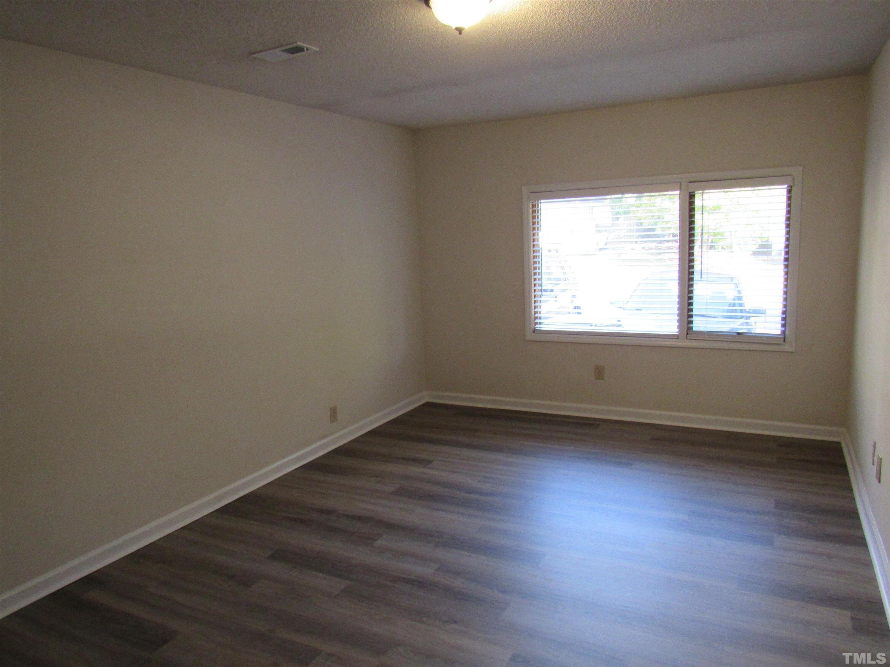 4309 Hunters Club Drive, Unit 4309 Raleigh, NC 27606 - Photo 14 of 35 an empty room with wooden floor and windows