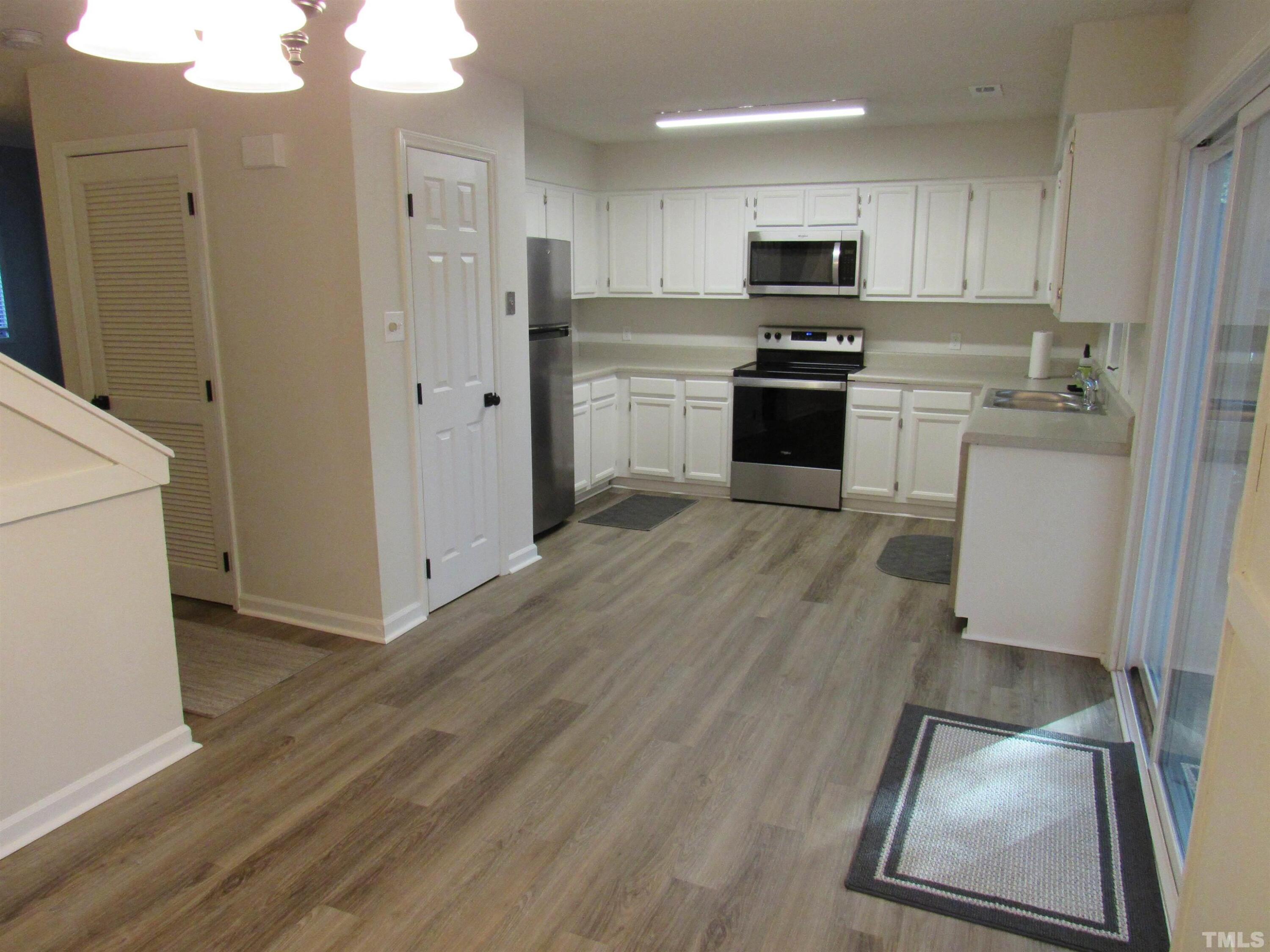 4309 Hunters Club Drive, Unit 4309 Raleigh, NC 27606 - Photo 22 of 35 a kitchen with granite countertop a refrigerator stove top oven and sink