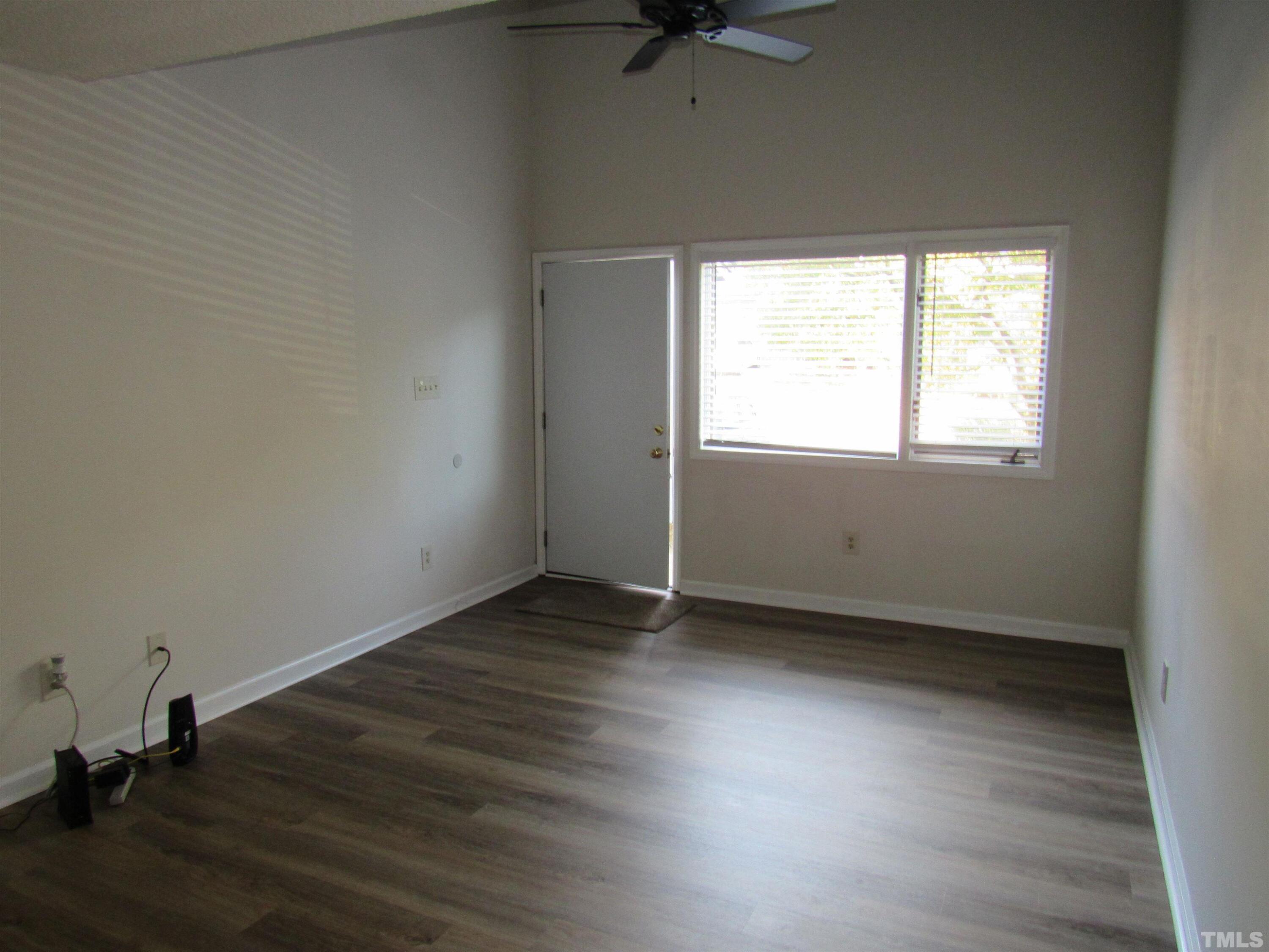 4309 Hunters Club Drive, Unit 4309 Raleigh, NC 27606 - Photo 8 of 35 an empty room with wooden floor and windows