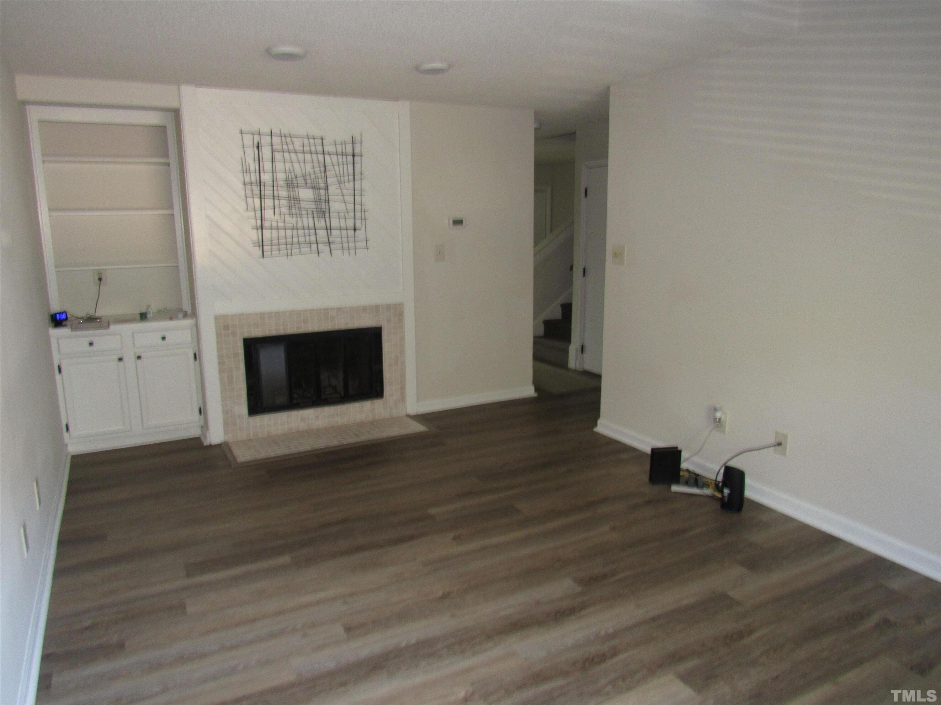 4309 Hunters Club Drive, Unit 4309 Raleigh, NC 27606 - Photo 9 of 35 a view of empty room with wooden floor and fireplace